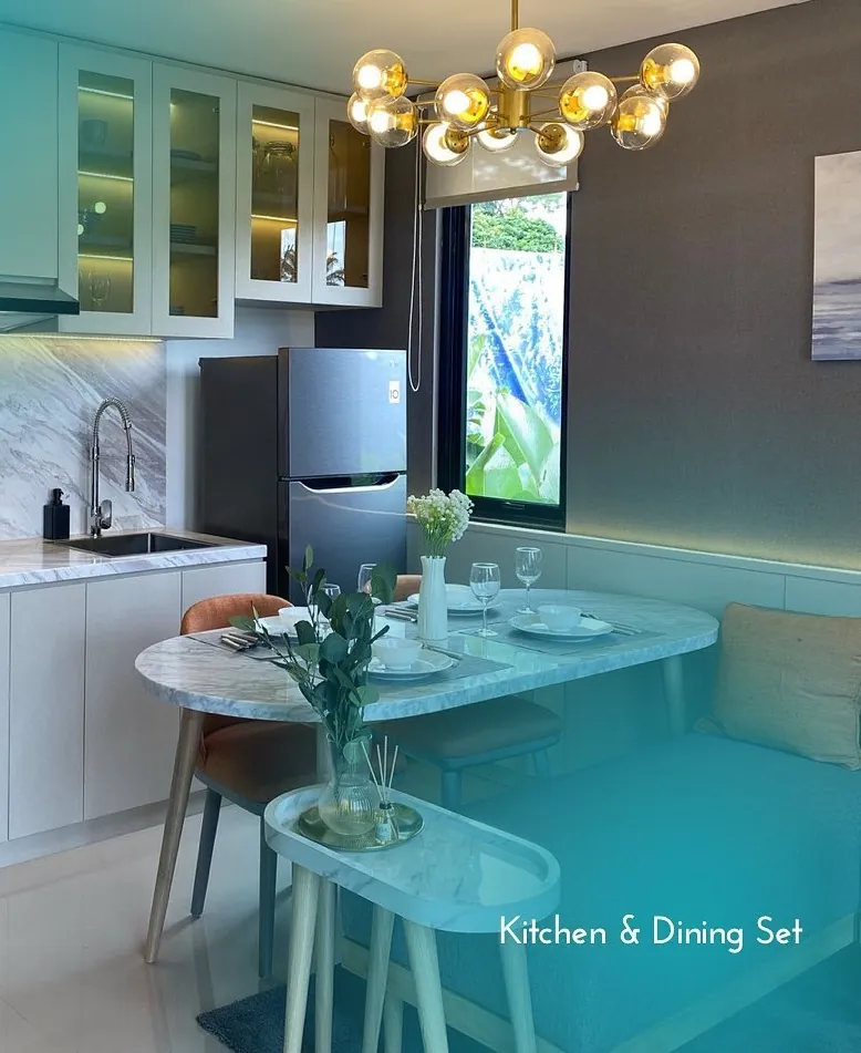 White kitchen with a marble backsplash and a chandelier over the dining table